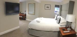 a bedroom with a large white bed and a desk at The Bulls Head in Swadlincote