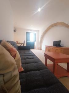 a living room with a couch and a table at Tomarhousing - Style in Tomar