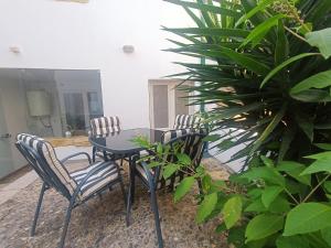 three chairs and a table in a room with plants at Tomarhousing - Style in Tomar