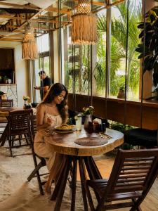 a woman sitting at a table in a restaurant at Olivia Oceanfront Tulum in Tulum