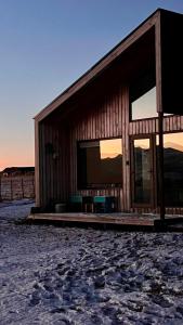 a wooden barn with a bench in front of it at Cabaña Julián Elias Verde in Puerto Natales