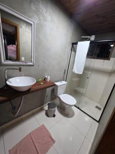 a bathroom with a sink and a toilet and a mirror at Formosa Suites in Bonito