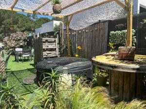 a garden with a pergola and a table and chairs at Les Suites du XV in Cap d'Agde