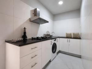 a white kitchen with a stove and a washing machine at Portal de Santa Maria in Santa Maria