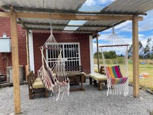 a patio with two hammocks and a table and chairs at Quinta Los Ángeles in Riobamba