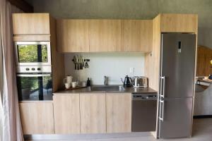 a kitchen with wooden cabinets and a stainless steel refrigerator at Interior designers second home FREE BIKES in Tulum