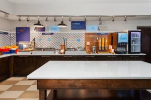 Holiday Inn Express Olean, NY في أوليان: مطبخ به طاولة ومنضدة