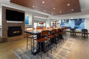 Holiday Inn Express Olean, NY في أوليان: غرفة طعام بها بار ومدفأة