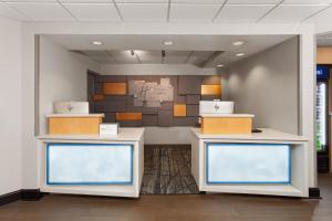Holiday Inn Express Olean, NY في أوليان: غرفة انتظار بها طاولتان وجدار +50 صورة