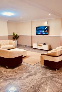 a living room with couches and a flat screen tv at The Castle Private Villa in Aso