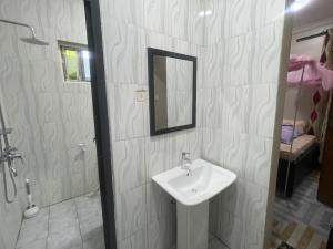 a white bathroom with a sink and a mirror at The John's Park in Mwanza