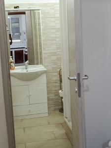 a white bathroom with a sink and a mirror at MisterBeB in Misterbianco +3 photos