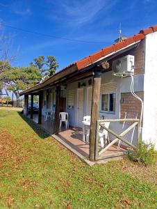 a small house with a porch and a lawn at Hotel de Campo con Piscina y Cabañas- Ideal Relax en Concordia in Concordia