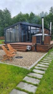 a house with a bench and a chair in a yard at SHKLO Lake&SPA in Shklo