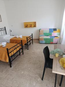 a room with two beds and two tables and chairs at MisterBeB in Misterbianco