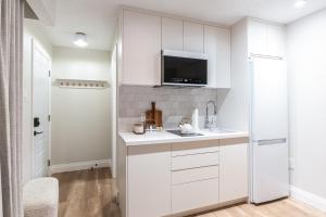 a white kitchen with a sink and a refrigerator at Sand and Stone Resort in Huntsville +63 photos