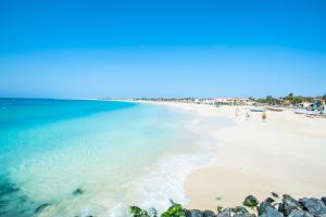 a beach with people walking on the sand and the water at Portal de Santa Maria in Santa Maria