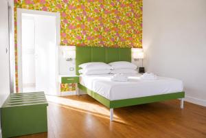 a bedroom with a bed with a green headboard at B&B Pellicano Guest House in Reggio di Calabria
