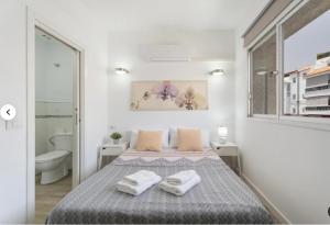a white bedroom with a bed and a bathroom at Habitaciones IFAE in Alcalá