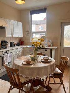 a kitchen with a table with a vase of flowers on it at The Blackburn 2 Bedroom House in Cherry Tree