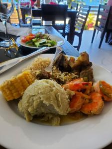 a plate of food with shrimp and vegetables on a table at Cozy Room with fast Internet & Netflix in Whitehall