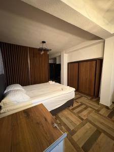 a large bed in a room with a wooden floor at Saymon apartment Trpejca in Ohrid