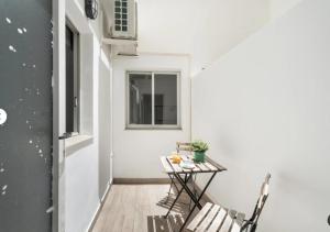 a small balcony with a table and chairs at Habitaciones IFAE in Alcalá
