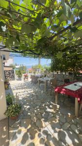 a patio with tables and chairs and a view of the ocean at Saymon apartment Trpejca in Ohrid +5 photos