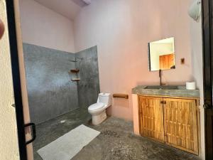 a bathroom with a toilet and a sink and a mirror at M a r e a V i v a - Z i p o l i t e in Zipolite +85 photos
