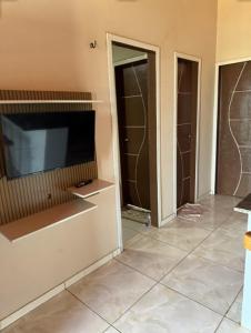 a living room with a television and a tiled floor at Chalés Panulirus in Icapuí +32 photos