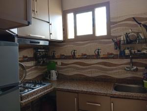 a kitchen with a sink and a stove and a window at casa chawni in Chefchaouen
