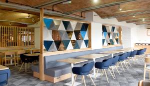 a restaurant with a row of tables and chairs at Holiday Inn Express Liverpool-Albert Dock by IHG in Liverpool