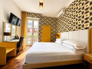 a hotel room with a bed and a desk at B&B Pellicano Guest House in Reggio di Calabria