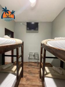 a room with two bunk beds and a flat screen tv at Hospedaria Monterrey - Entre Hortolândia e Monte Mor in Monte Mor