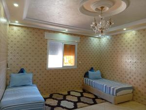 a bedroom with two beds and a chandelier at casa chawni in Chefchaouen +11 photos