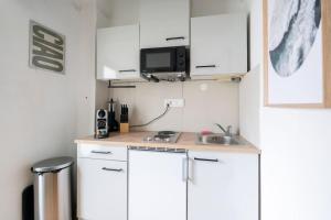 a small kitchen with white cabinets and a sink at Apartment at Main Square - 35 m2 - Netflix - Quiet in Leoben