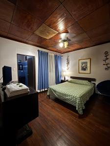 a bedroom with a bed and a wooden ceiling at Charly's Place in Alajuela