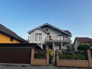 a white house with a gate and a garage at Rus House in Cluj-Napoca