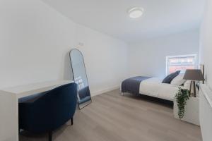 a bedroom with a bed and a desk and a mirror at 4 Bedroom modern apartment in Birkenhead