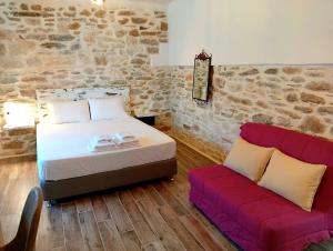a bedroom with a bed and a red couch at Tsonos Home in Keramídhion