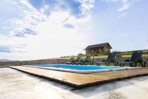 a pool with chairs and a house in the background at Brvnara Staničić sa privatnim bazenom in Arandelovac