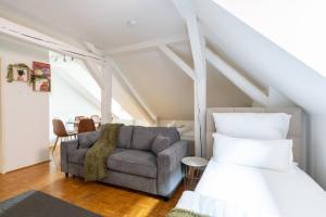a bedroom with a bed and a couch and a chair at Coyhomes Steyr Riverside - Serviced Apartments in Steyr