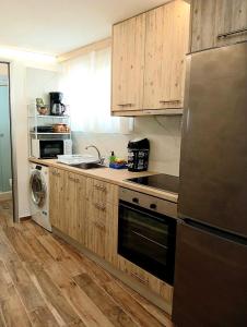 a kitchen with wooden cabinets and a stainless steel refrigerator at Tsonos Home in Keramídhion
