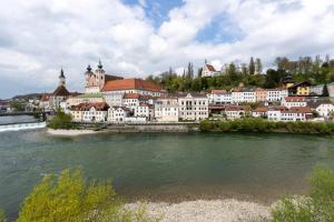 a city with a river and a town with buildings at Coyhomes Steyr Riverside - Serviced Apartments in Steyr