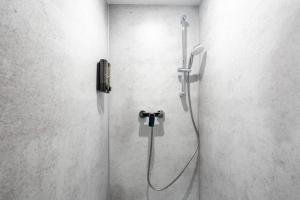 a shower in a bathroom with a phone on the wall at Coyhomes Steyr Riverside - Serviced Apartments in Steyr +71 photos