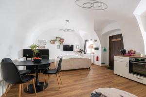 a kitchen and living room with a table and a bed at Coyhomes Steyr Riverside - Serviced Apartments in Steyr