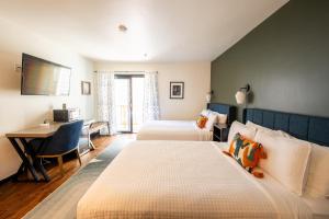a hotel room with two beds and a desk at Hotel Frisco in Frisco