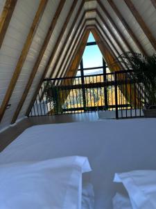 ein Bett in einem Zimmer mit Balkon in der Unterkunft Wild Hill Frames in Holbav