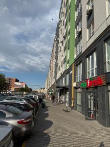a street with cars parked next to a building at Apartment Synergia 3 in Irpin