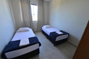 En eller flere senge i et værelse på Hotel Flat Ipatinga